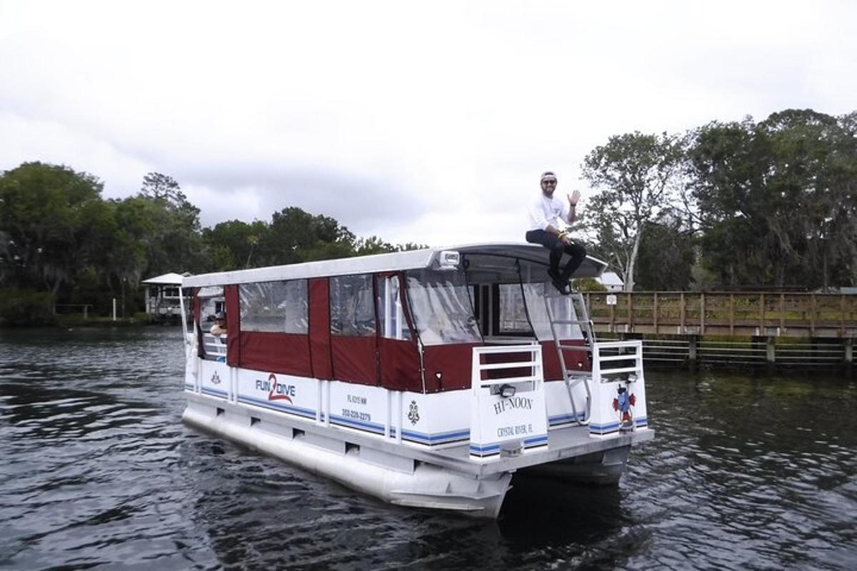 a man sitting on the roof of a boat on the water