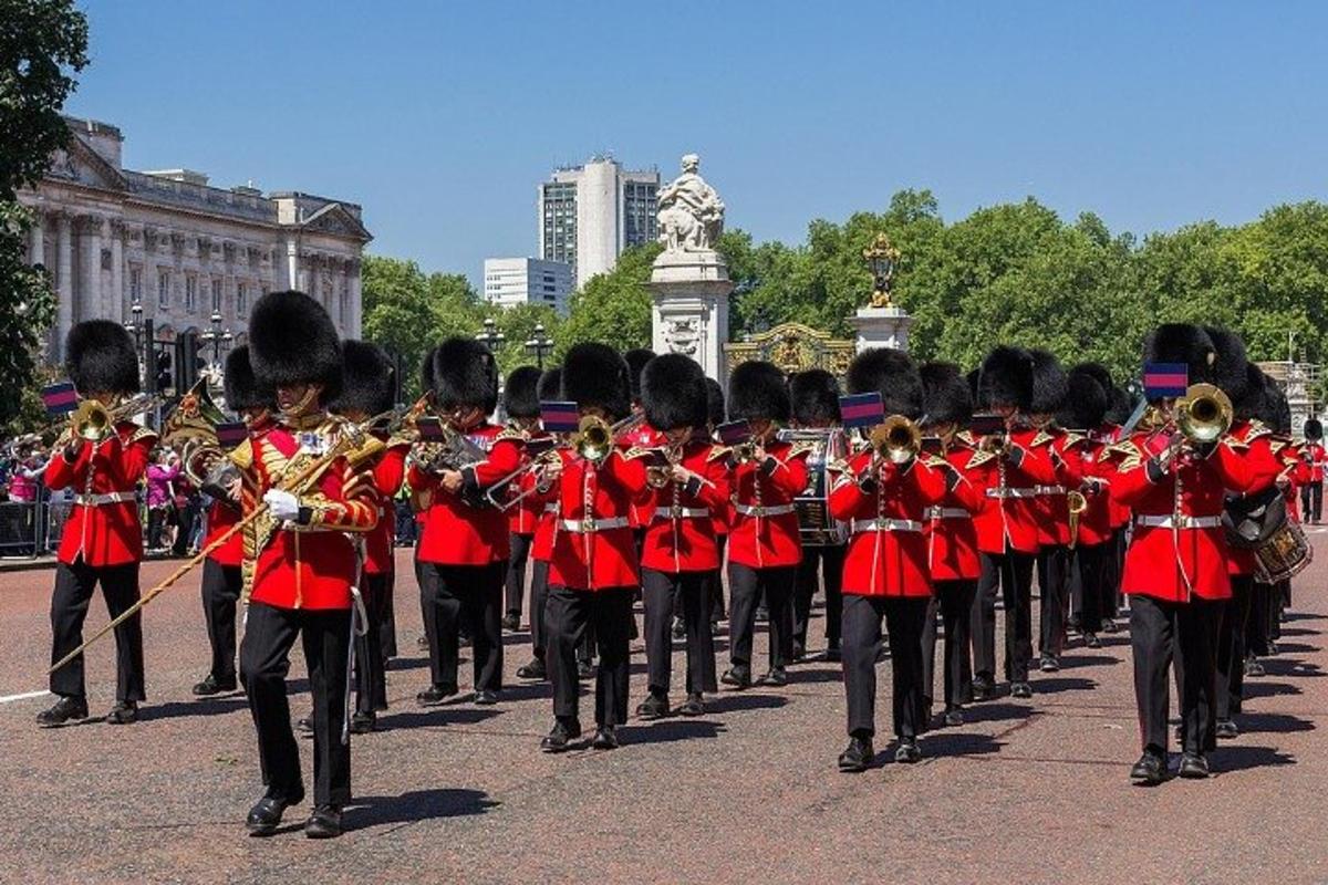 a marching band in red uniforms walking down the street