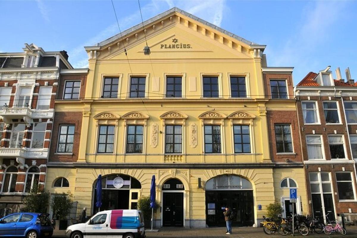 a yellow building on a street with cars parked in front