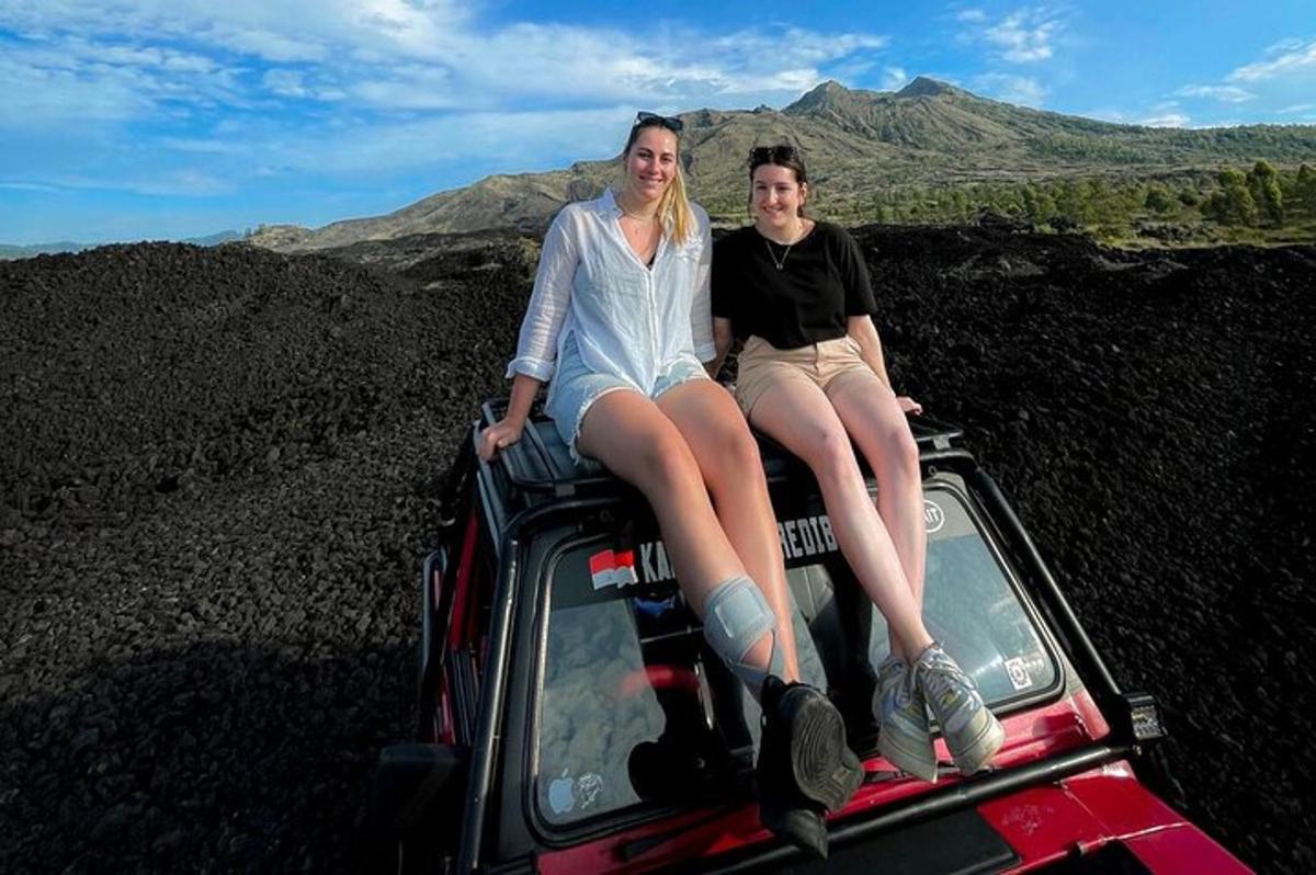 zwei Frauen sitzen auf der Ladefläche eines Jeeps