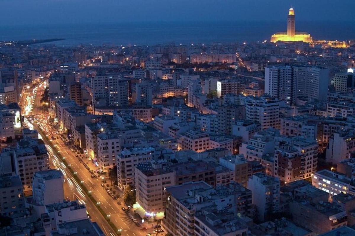 a city at night with a tower in the background