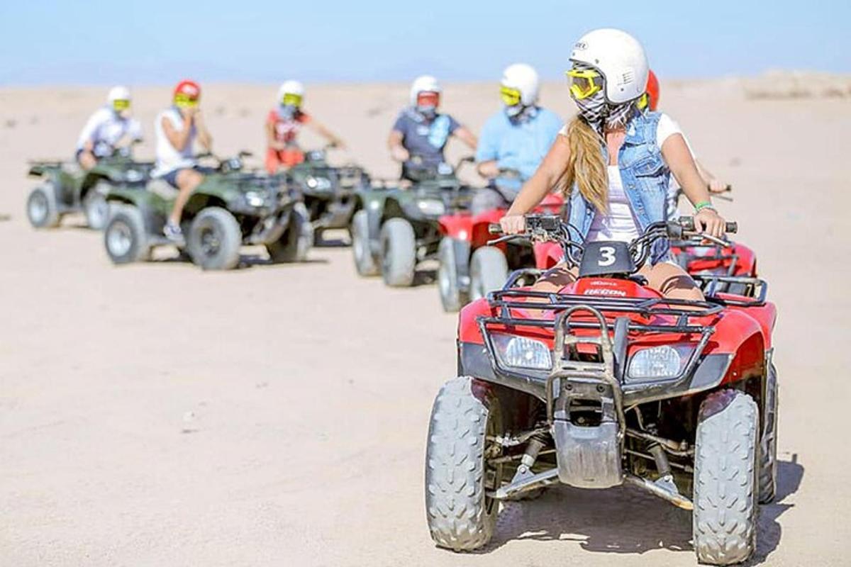 sekelompok orang mengendarai ATV di padang pasir