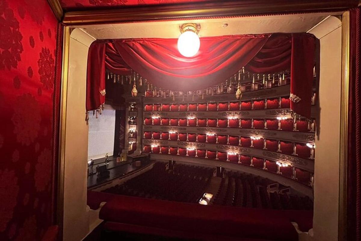 an auditorium with a red curtain in a theatre
