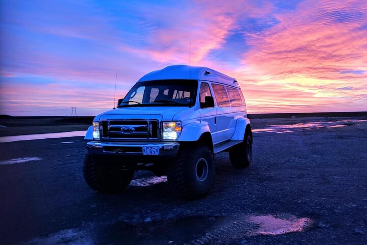 um caminhão branco estacionado em um estacionamento com um pôr do sol