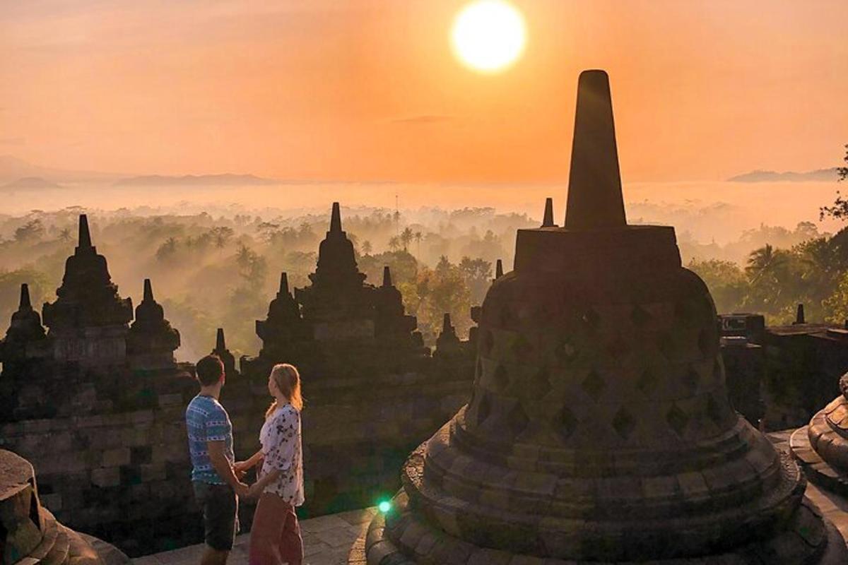 Una pareja parada frente a un templo al atardecer