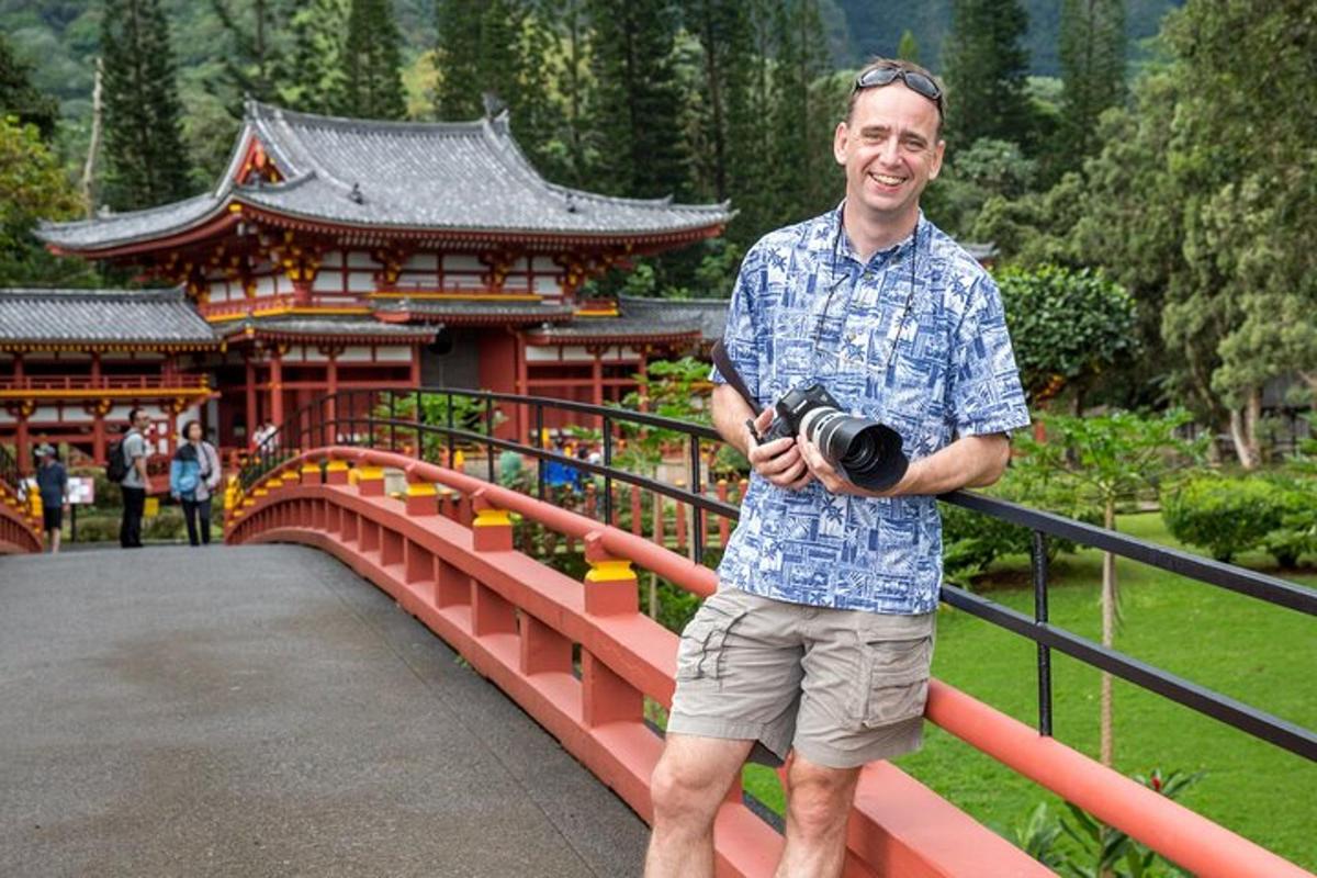 un uomo in piedi su un ponte con in mano una macchina fotografica