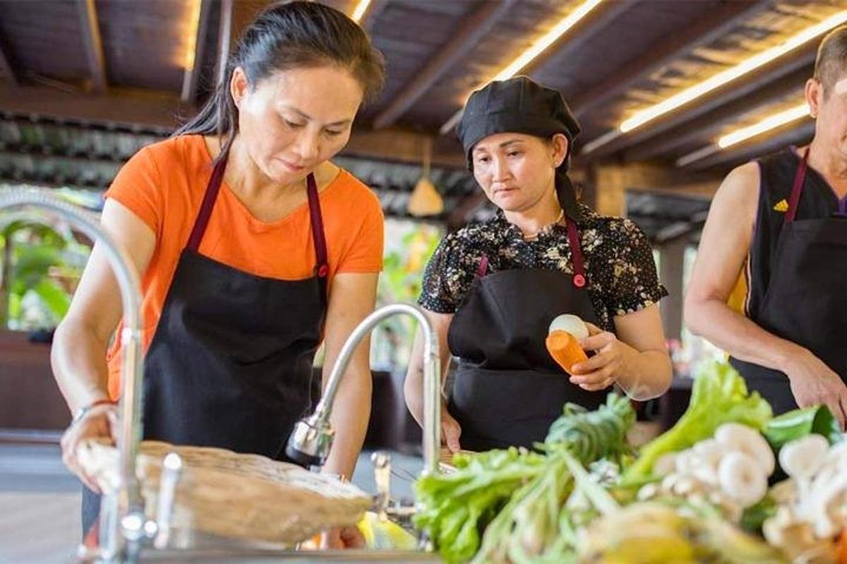 Dos mujeres de pie en una cocina preparando comida