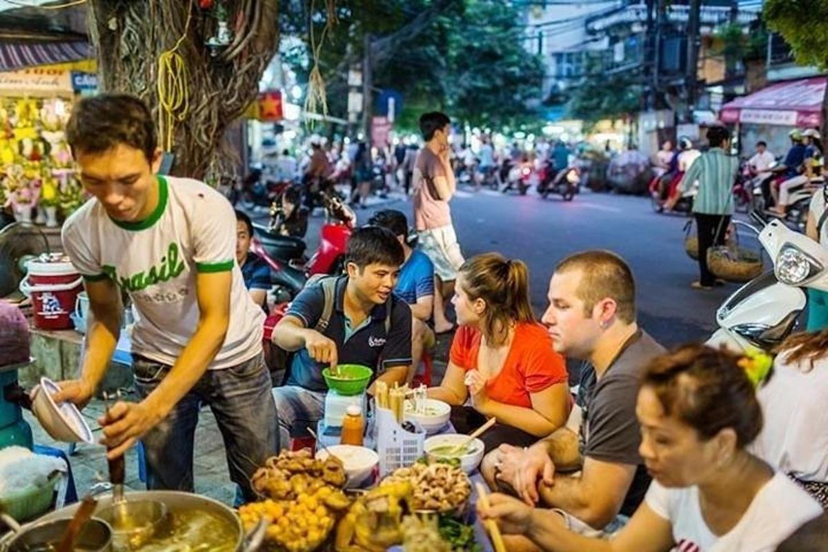 một nhóm người đang ngồi quanh một cái bàn với đồ ăn