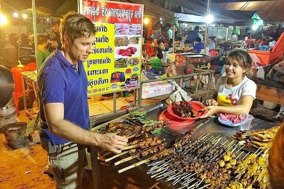 một người đàn ông và một người phụ nữ đang chuẩn bị thức ăn ở chợ