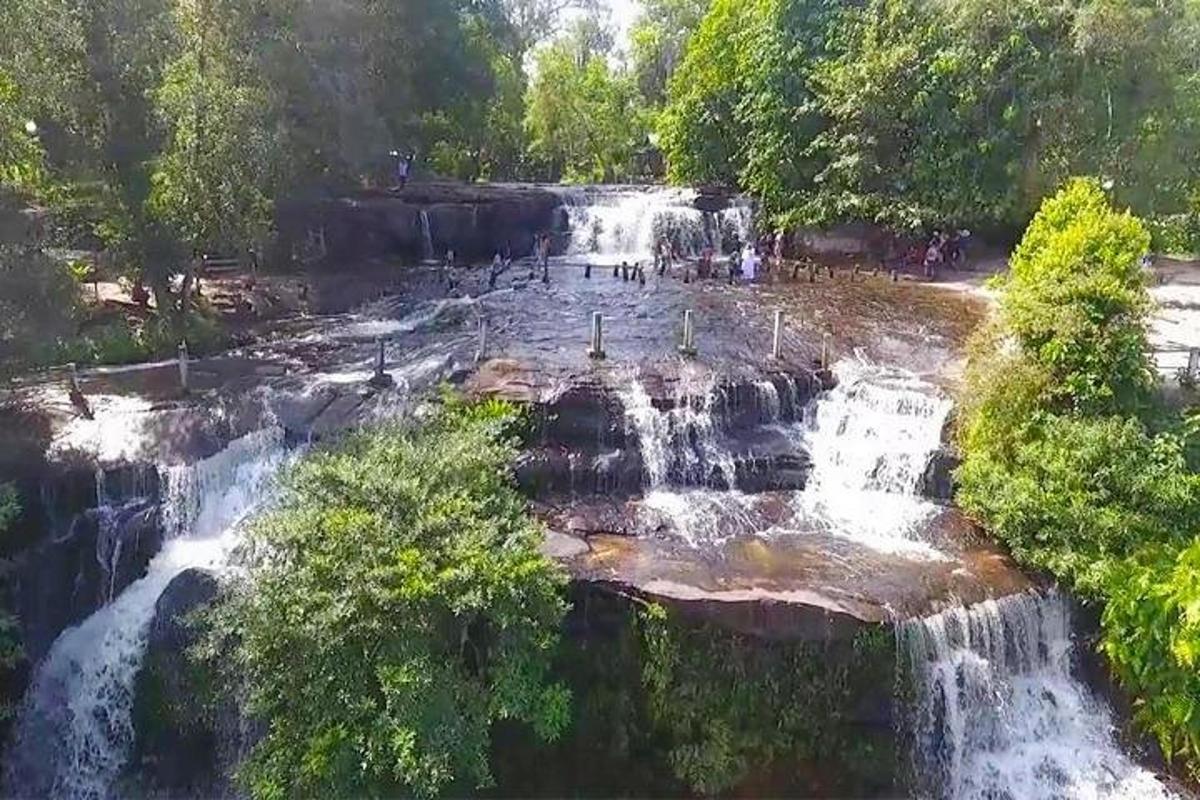 une cascade dans un parc avec des gens debout dedans