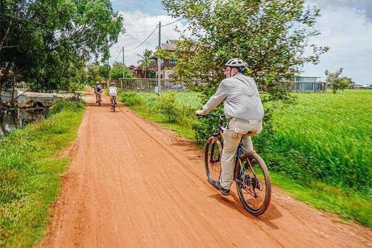 muž jazdiaci na bicykli po prašnej ceste