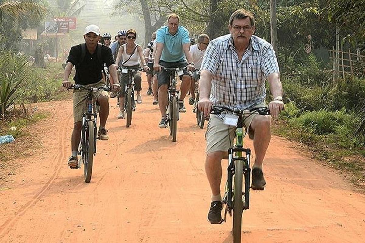 skupina ľudí jazdiacich na bicykloch po prašnej ceste