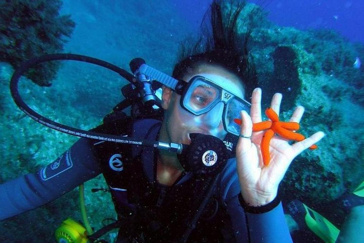 una persona che scatta una foto a un subacqueo con una macchina fotografica