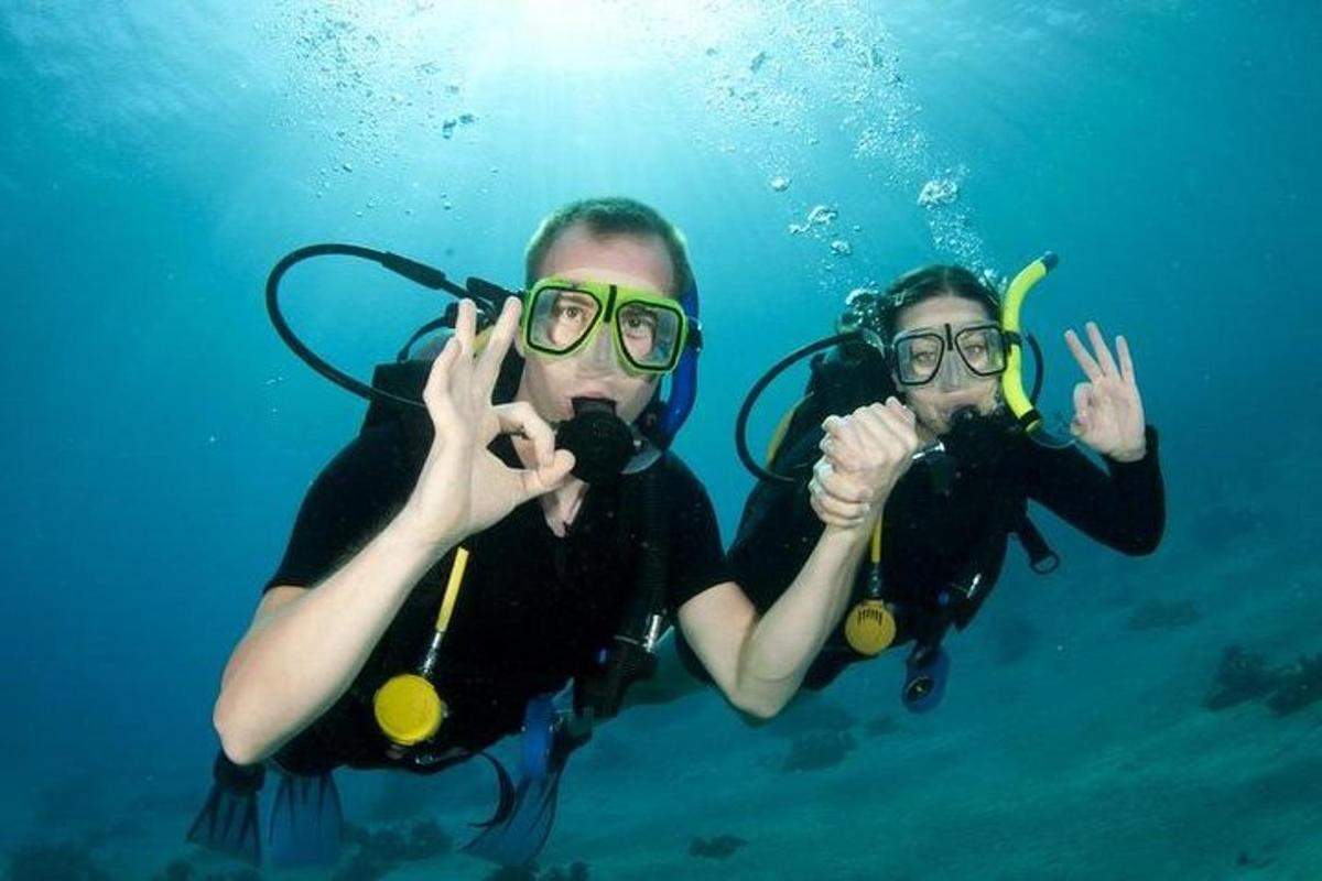 due persone in acqua che fanno il segno della pace