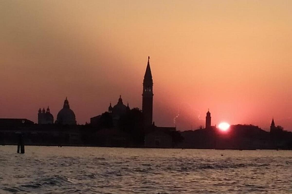um pôr do sol sobre uma cidade com uma torre do relógio