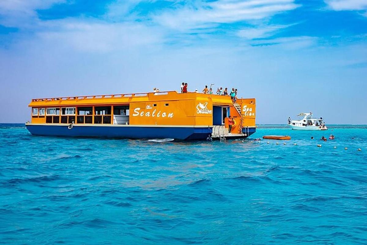 an orange boat in the water with people on it