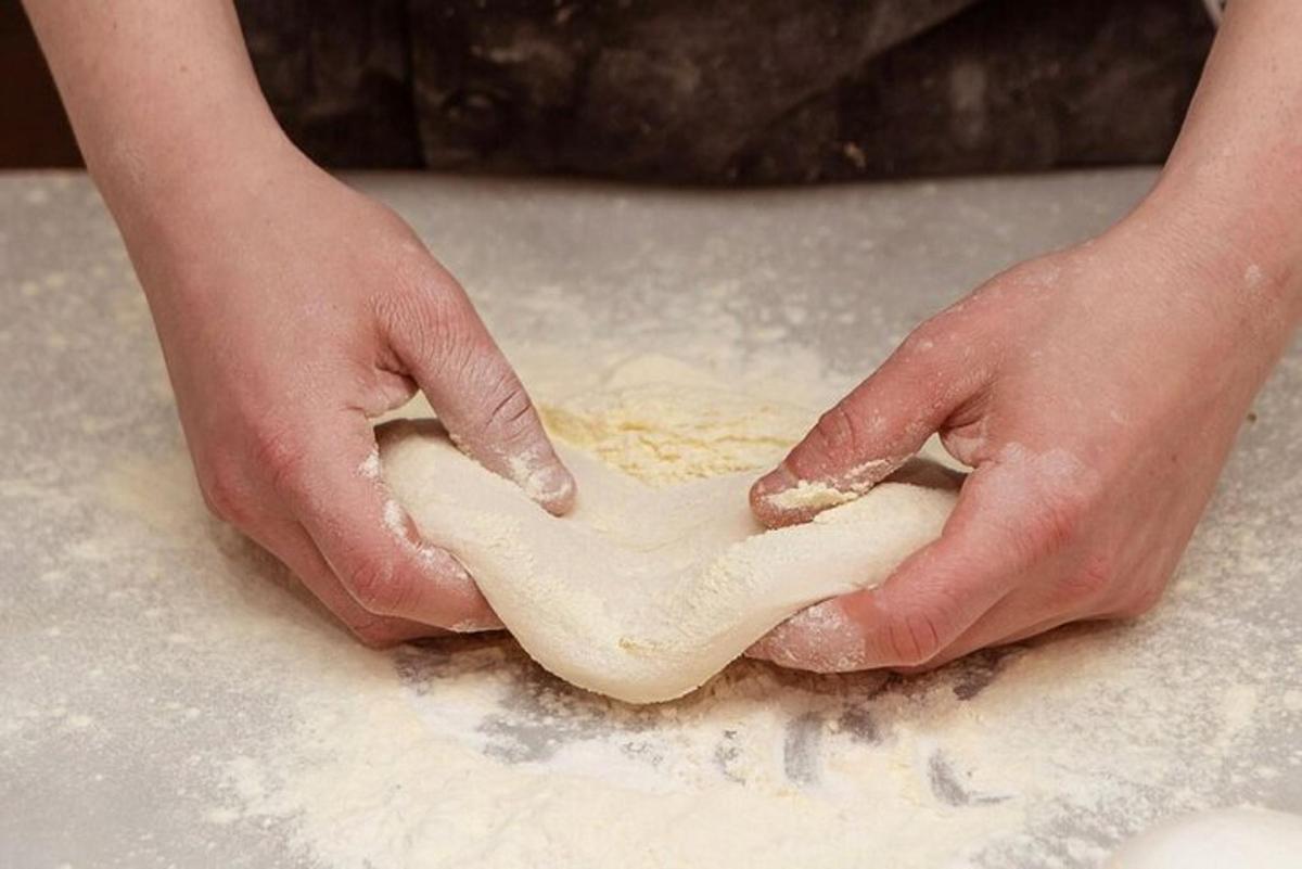 una persona che impasta con le mani sul tavolo