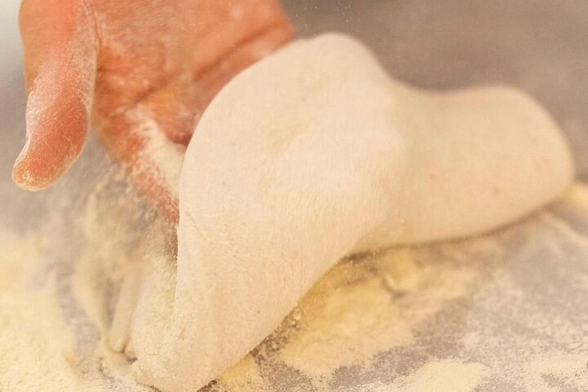 una persona que sostiene un trozo de masa en un tazón