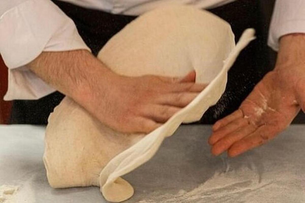 una persona che impasta un impasto su un tavolo