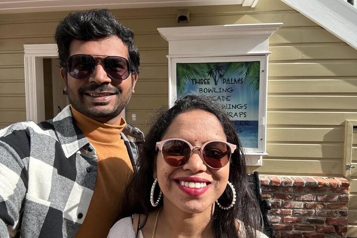 a man and a woman standing in front of a house