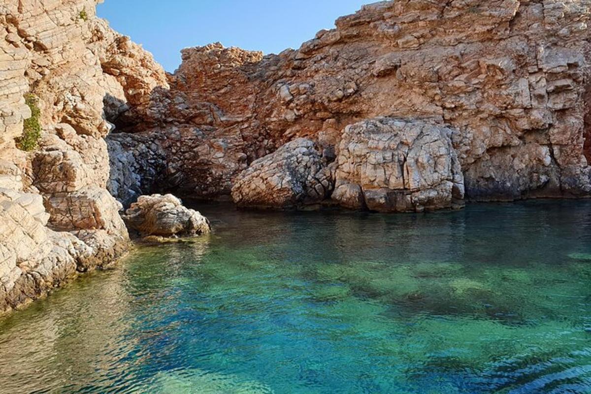 a body of water next to a rocky cliff