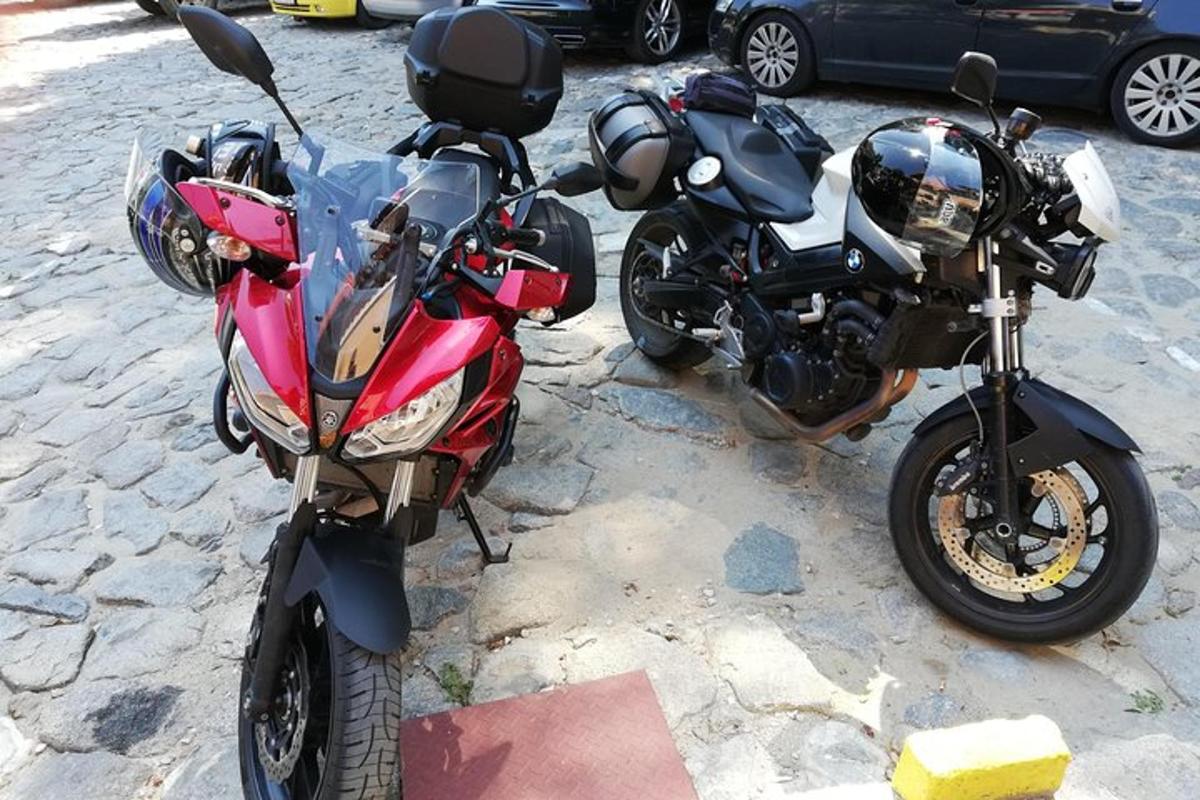 dva motorna kolesa parkirana drug poleg drugega na ulici