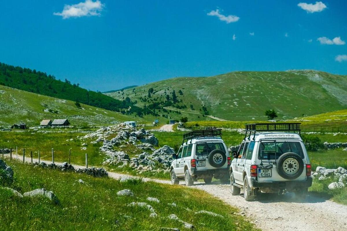due auto parcheggiate su una strada sterrata su una collina