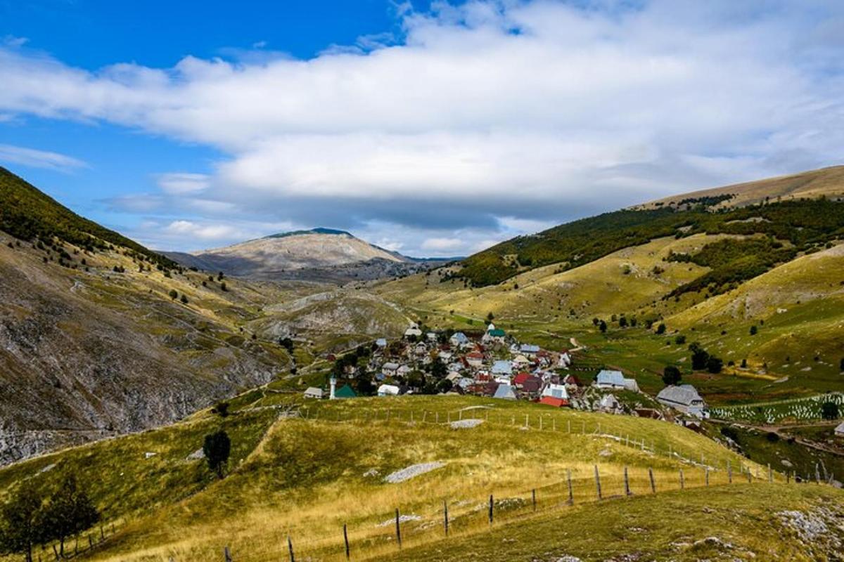 un villaggio su una collina con le montagne sullo sfondo