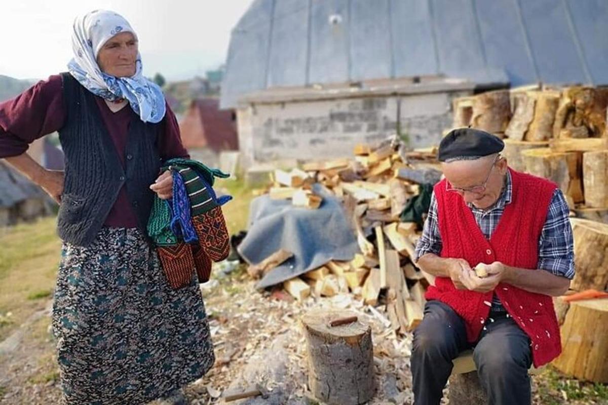 due donne anziane in piedi accanto a una catasta di legna