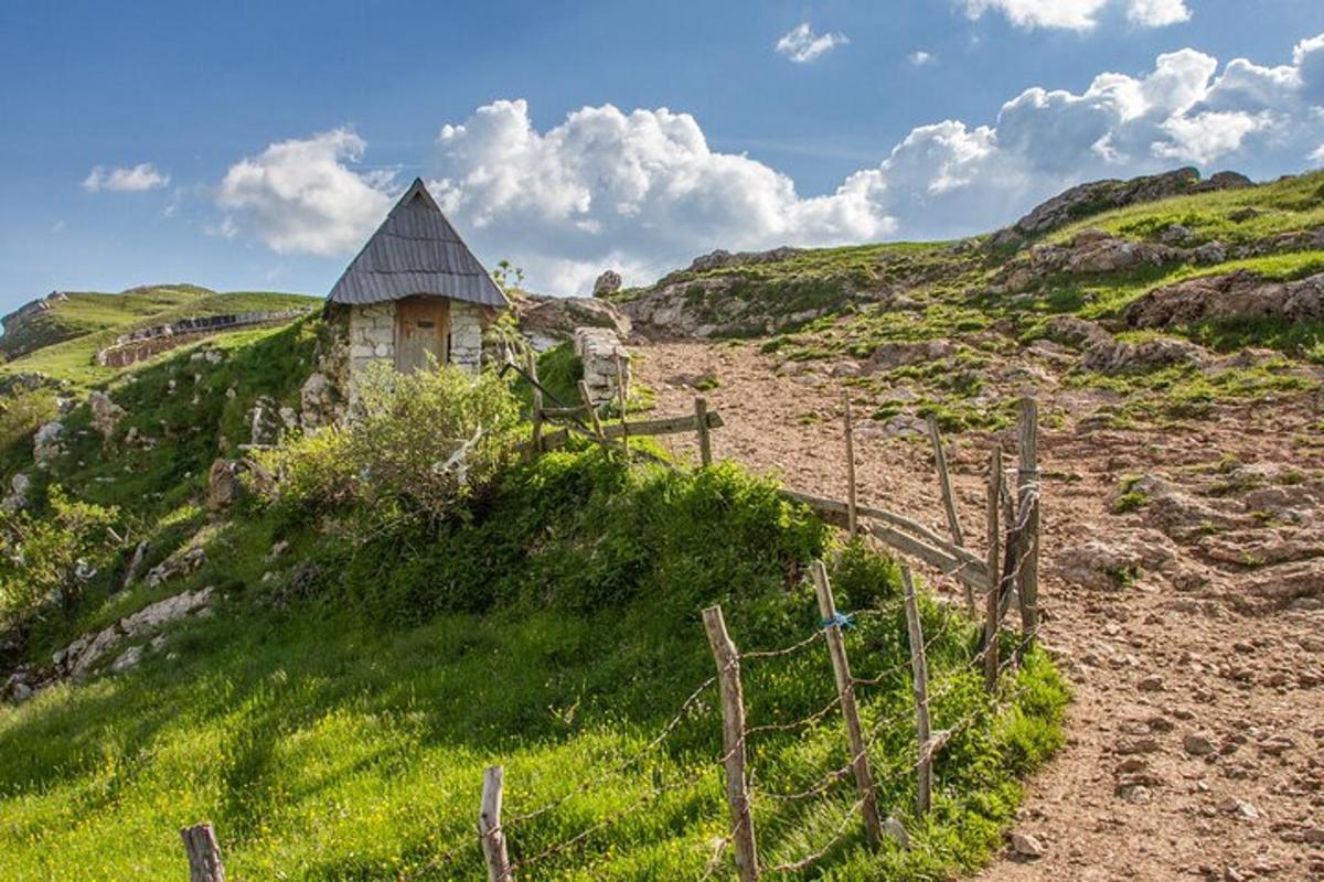 un vecchio edificio su una collina con una recinzione