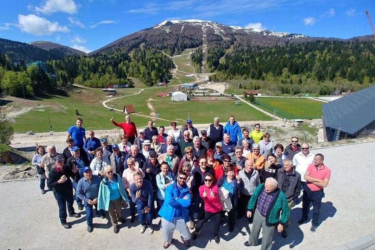 Un grupo de personas posando para una foto frente a una montaña.
