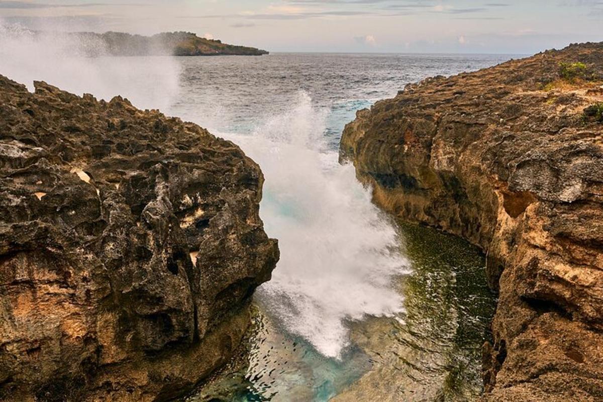 a wave crashing on a cliff next to the ocean