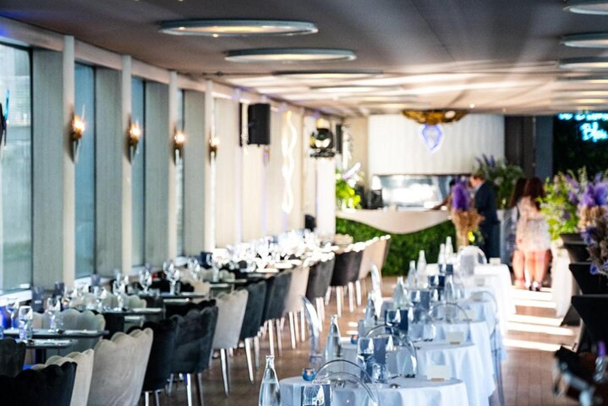 a banquet hall with white tables and chairs and people