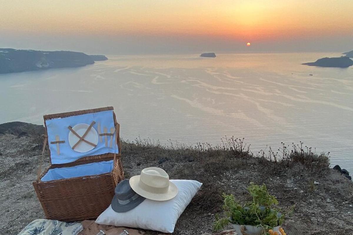 židle a klobouk sedící na kopci s oceánem