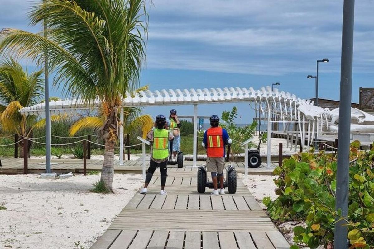 a group of people standing on a boardwalk on the beach