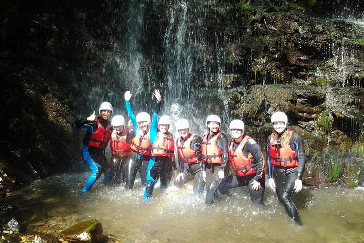 un grup de persones a l'aigua davant d'una cascada