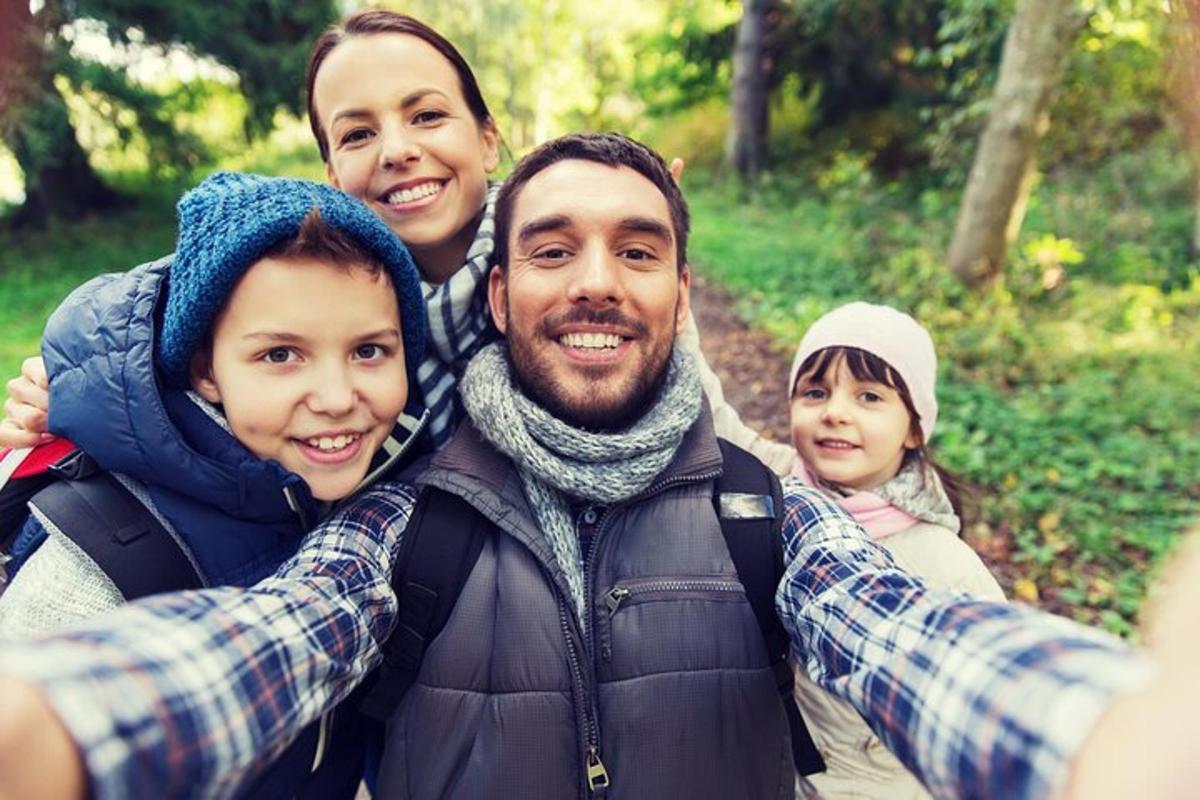 un uomo e due ragazze stanno scattando una foto di una famiglia