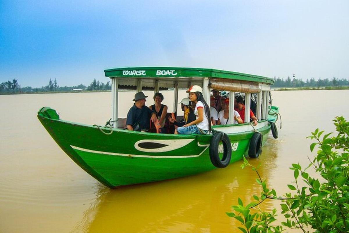 Un grupo de personas viajando en un bote verde en el agua.