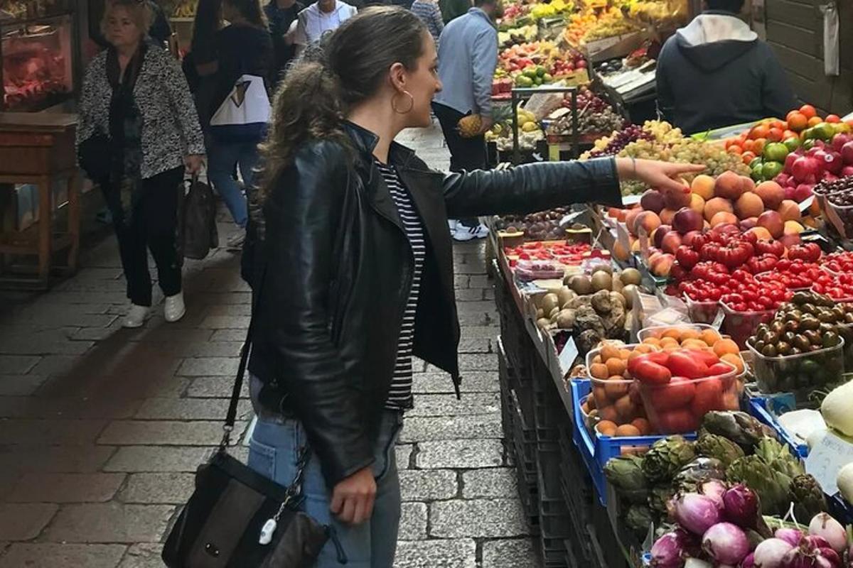 una dona dreta en un mercat assenyalant les verdures
