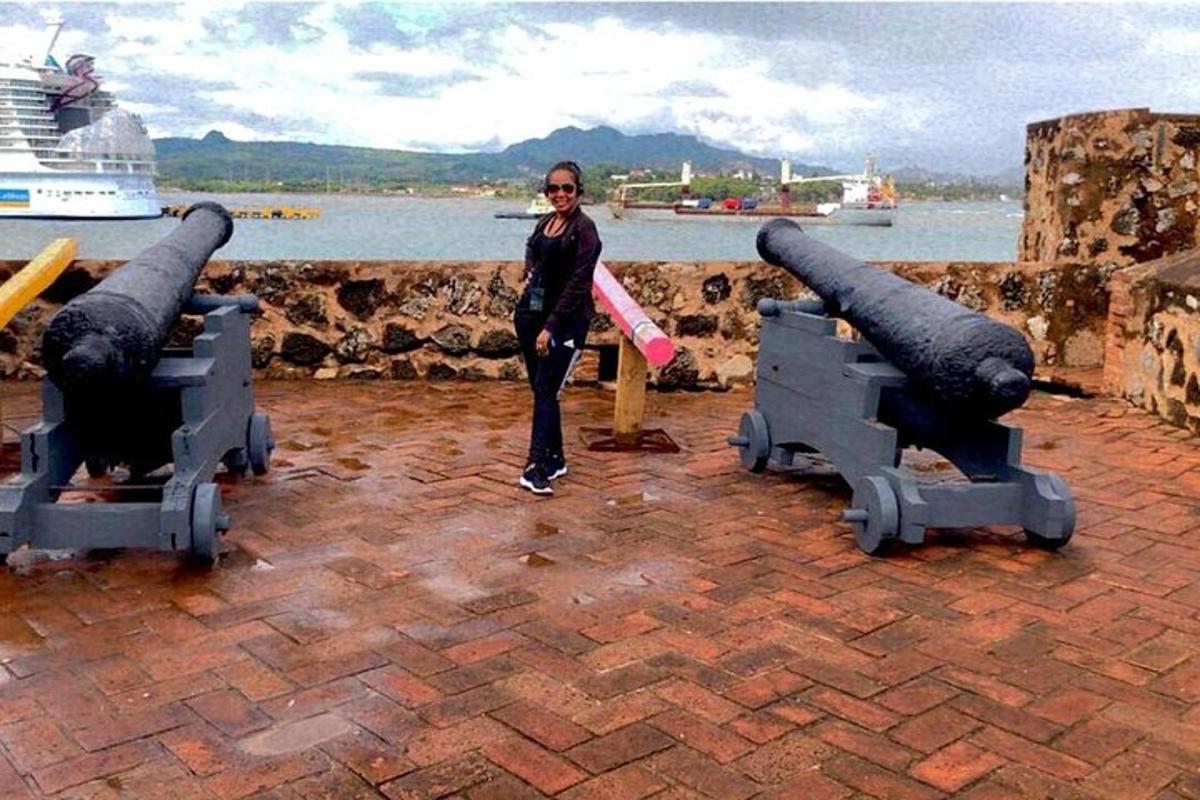 a woman standing in front of two large cannons