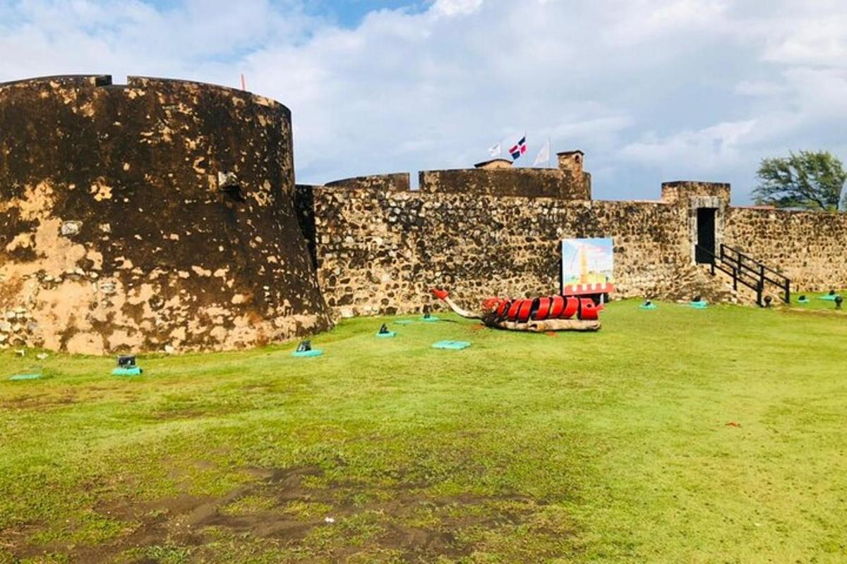 a castle with people sitting on the grass in front of it