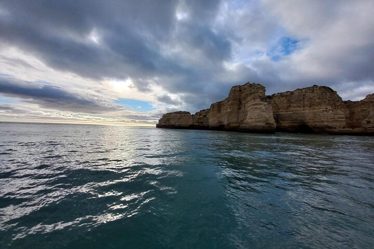 a boat in the water near some large rocks