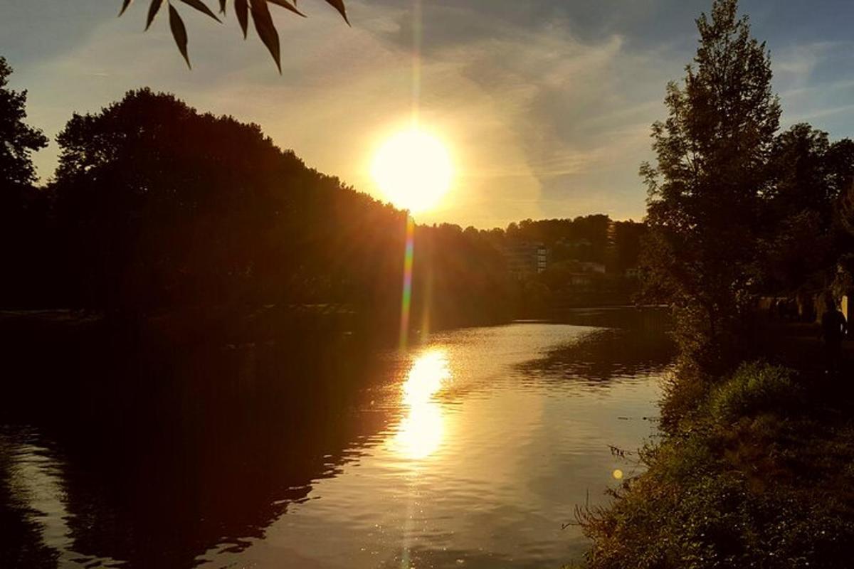 a river with the sun shining on the water