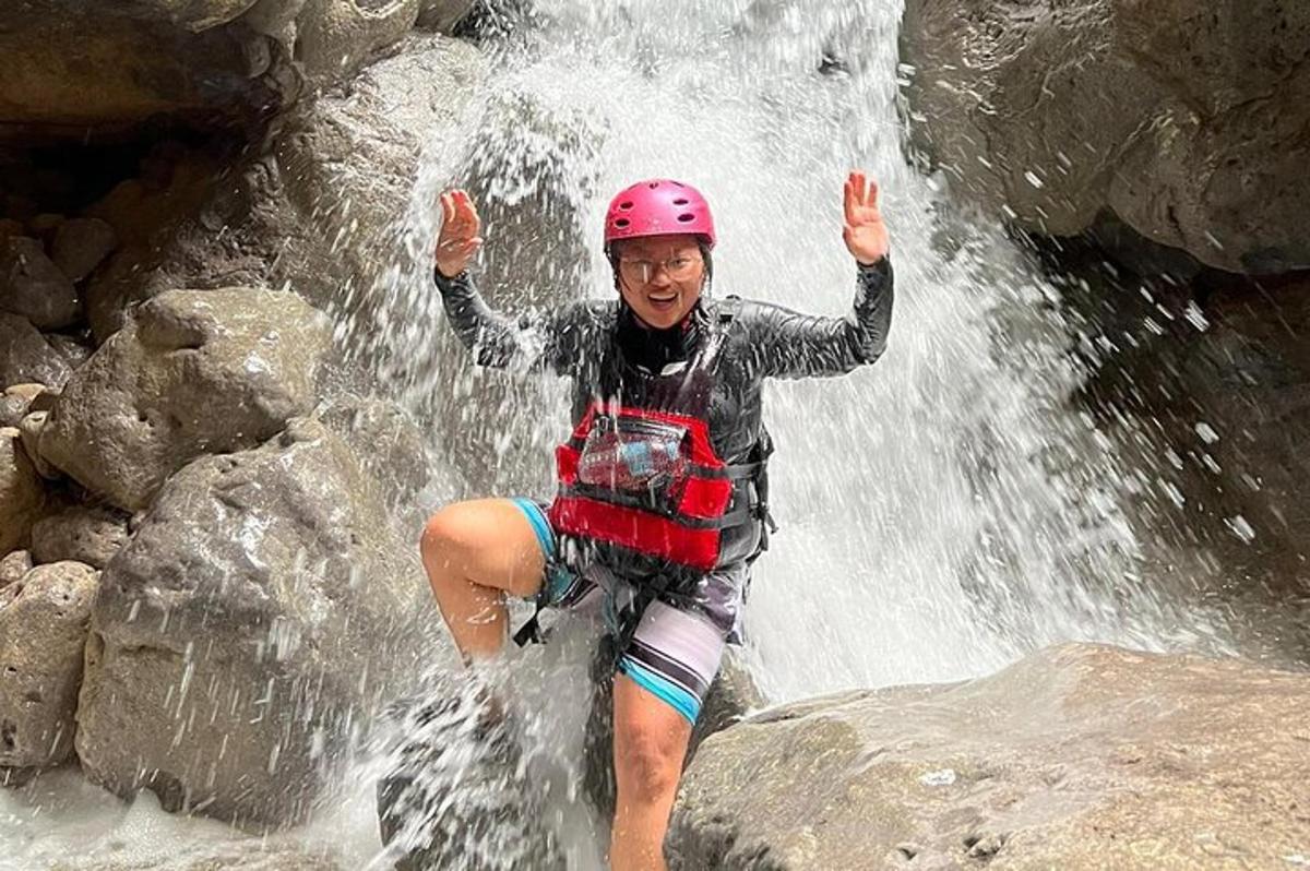 una donna con un casco in piedi davanti a una cascata