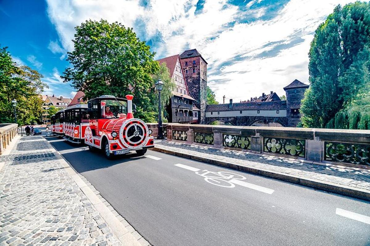 ein roter Zug, der eine Straße entlangfährt