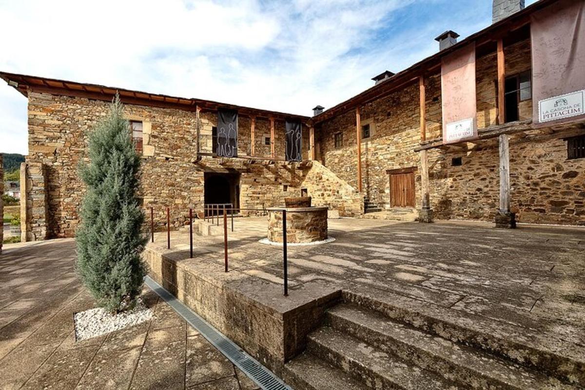 an old stone building with a tree in front of it