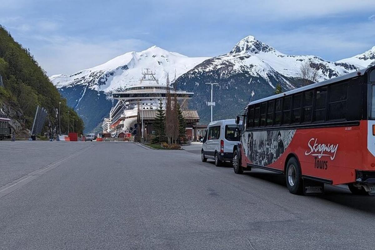 a bus driving down a street with mountains in the background