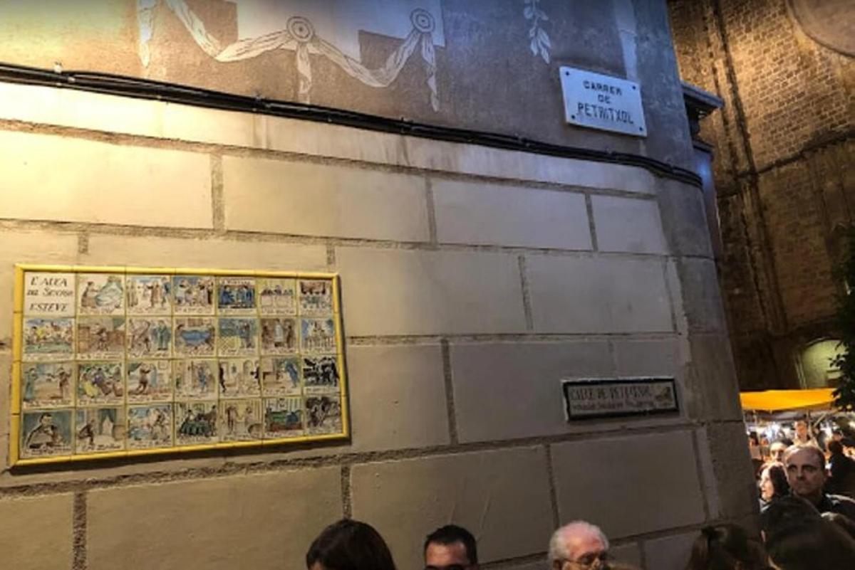 un grup de persones dretes al voltant d'una paret amb una imatge