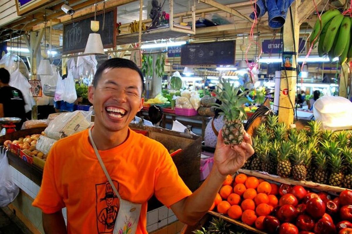 một người đàn ông đang cầm một quả dứa ở chợ