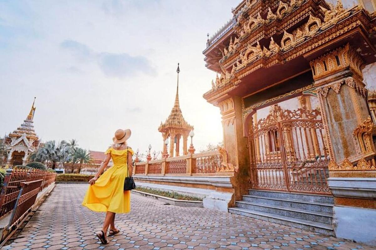 một người phụ nữ mặc váy vàng đứng trước một tòa nhà